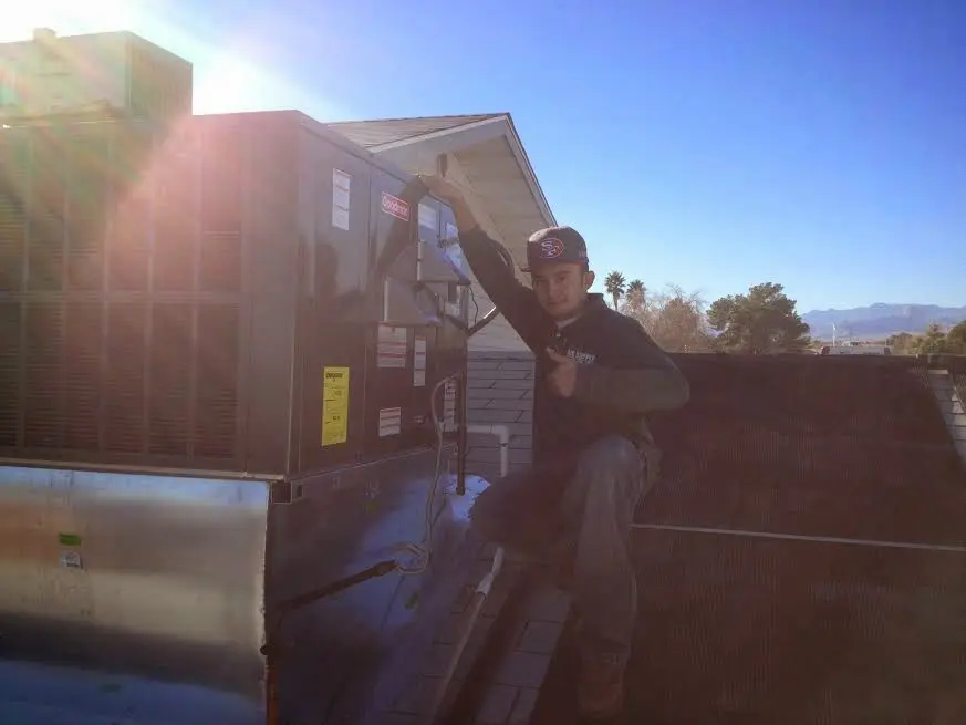 HVAC technician performing Air Duct Cleaning on a rooftop unit in Delta
